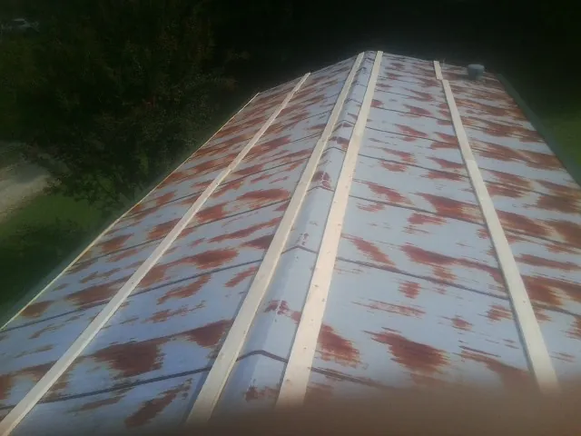 Rusted metal roof panels with new wood purlins before replacement — Storm Damage Roof Repair in Sunset by Roofing Brothers